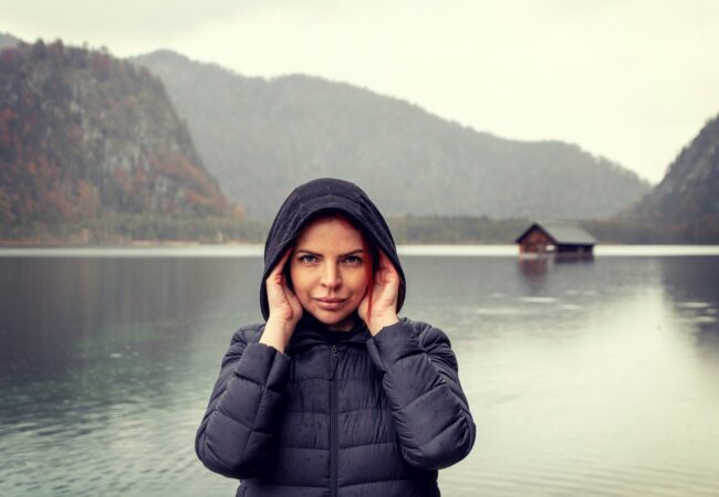 a woman standing in front of a body of water